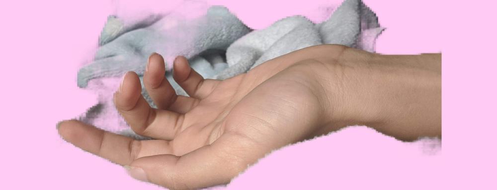 a digitally cropped hand with a soft blanket on a pink background