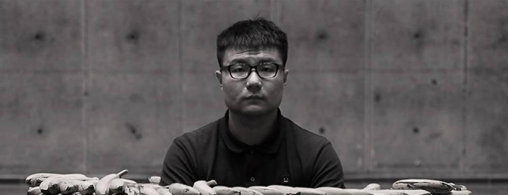 Man sitting in a circle well made of bananas.