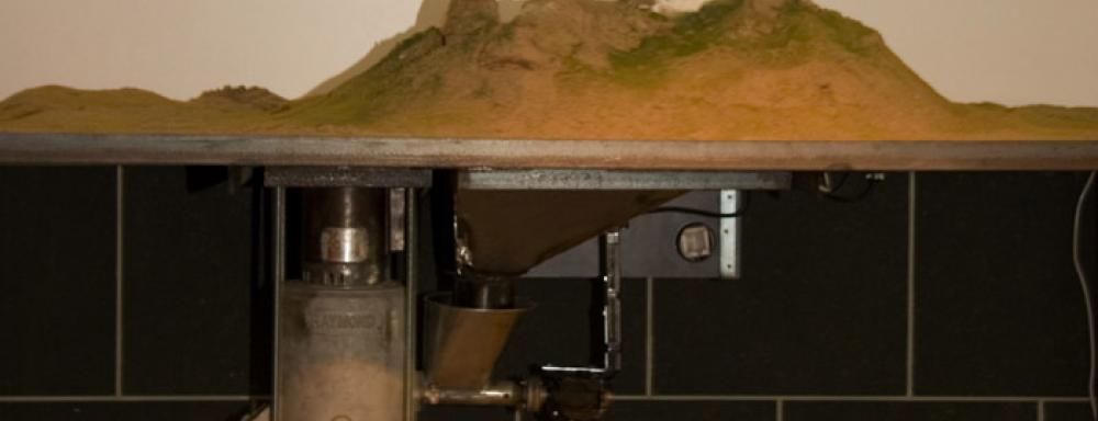 A machine holding up a diorama of a mountain. 