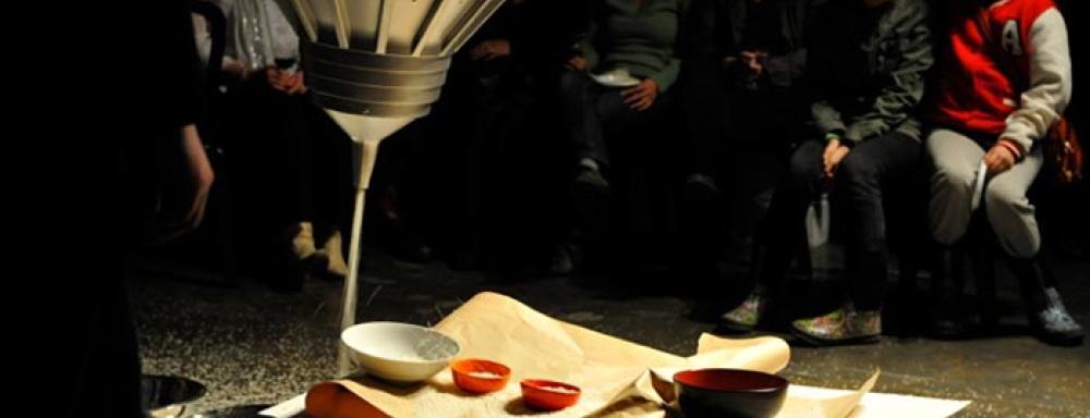 A sheet of paper on top of drums in which multiple different sized bowls sit. 