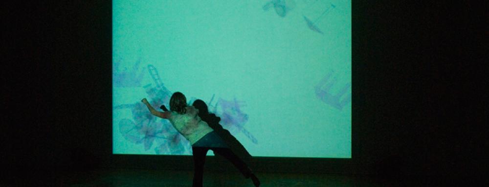 A woman standing in front of a colourful projection