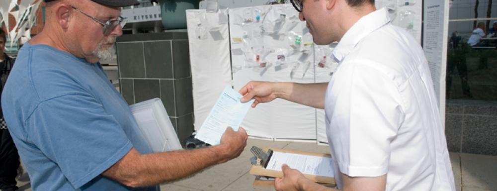 A man handing another man a paper