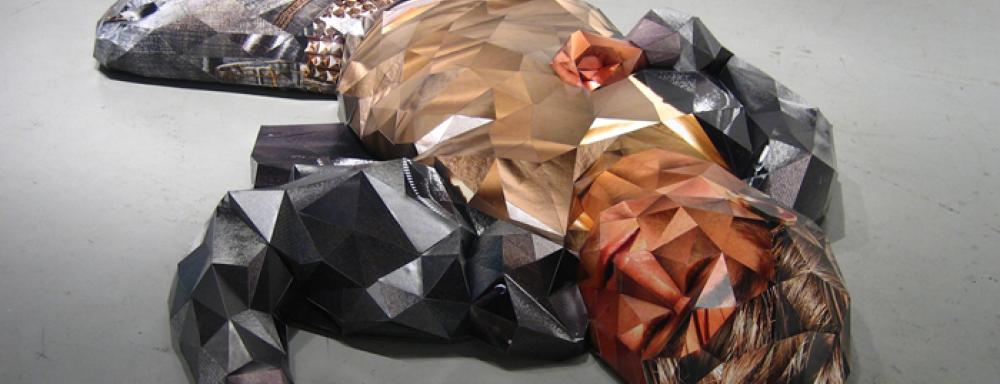 A sculpture of a man laying down. Using geometric shapes to create the figures shape.