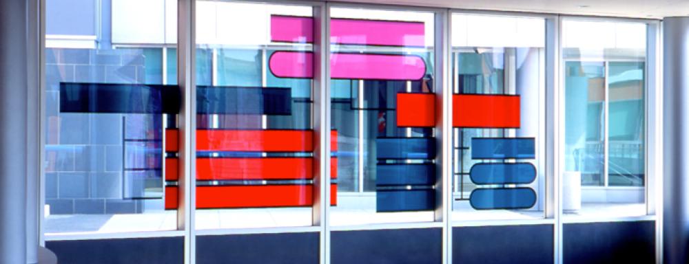 Windows with stain glass rectangles in colours red, magenta and dark grey.
