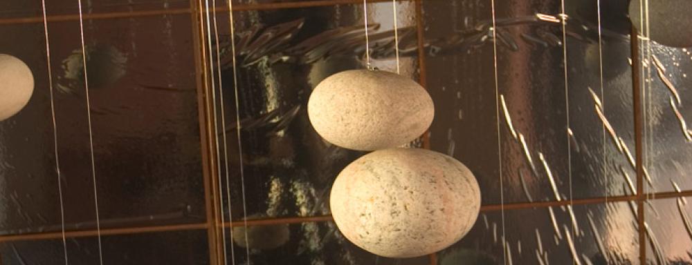 Rocks hanging from fishing wire. 