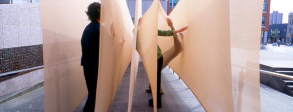 two individuals interacting with sculpture  