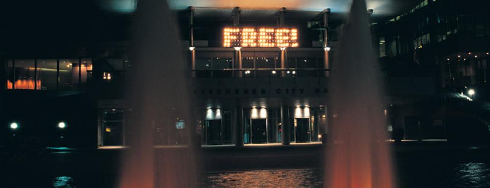 Image of Kitchener city hall with sign that says free using light bulbs