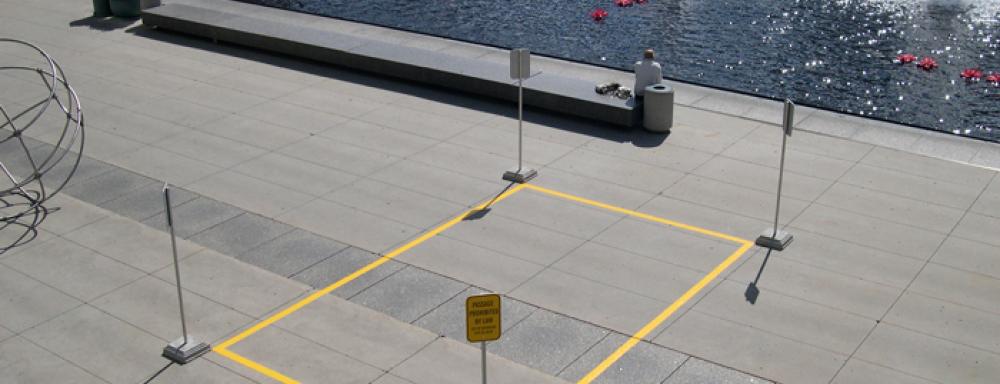 tarmac with yellow lines painted in a rectangle with reserved parking signs on each corner