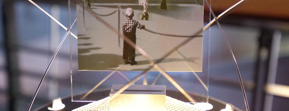 Postcard of little boy looking at plane on stand