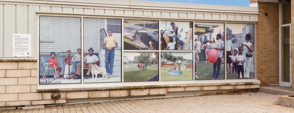 3/4 angle view of vinyl images installed on windows, depicting a black family in various candid shots.