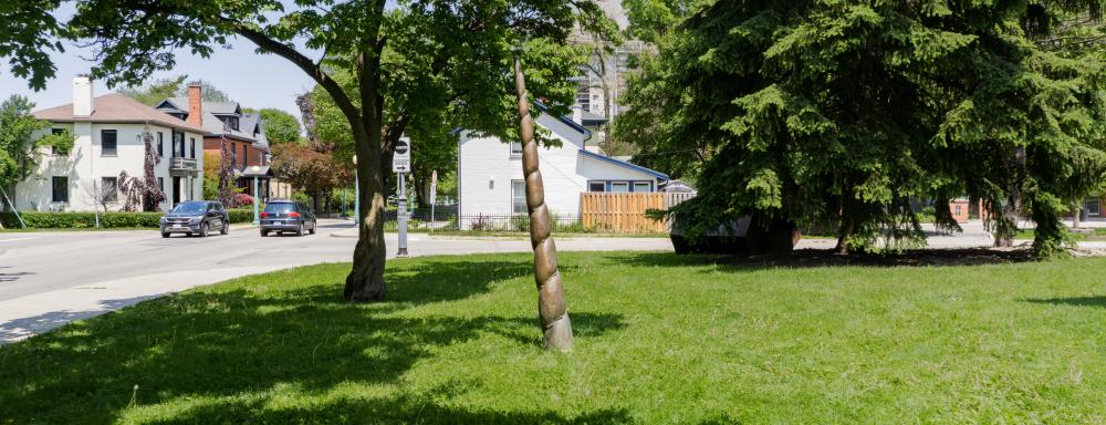 Bronze unicorn horn planted in a grass lawn.