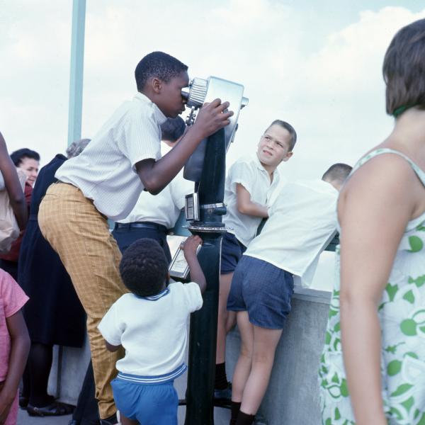 Boy looking though coin to pay binoculars 