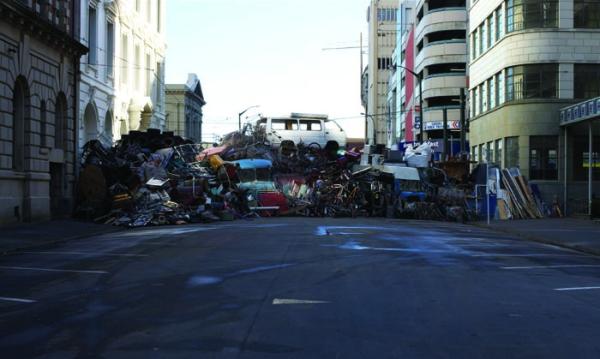 Image of a damn in a road made by various trash 