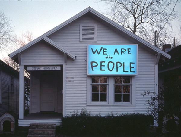 House with lit up sign that says we are the people