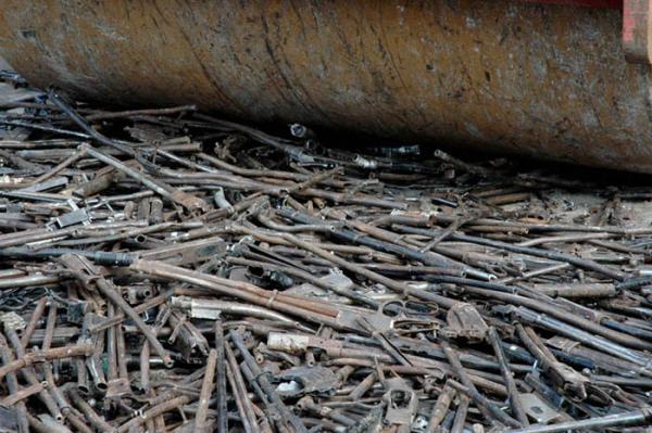Photo of shotguns being crushed being steam rolled
