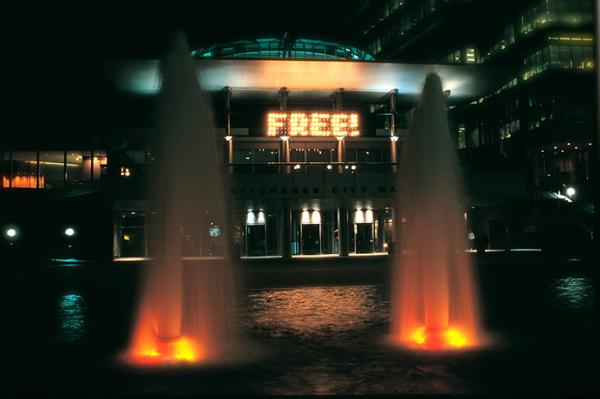 Fountains framing a lit up sign that says free