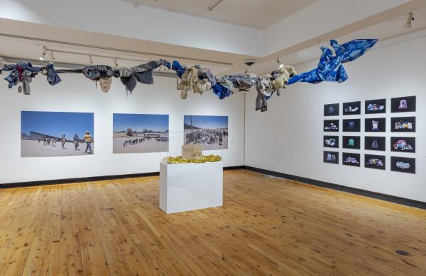 images on walls and art installation hanging from ceiling, above head.