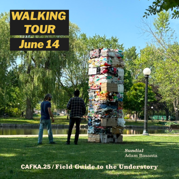 Image of a tower made from bales of compacted garbage. Two people stand in the park looking at it.